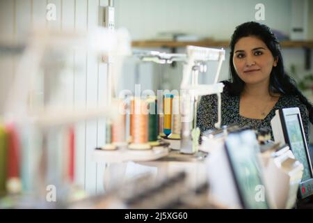 Portrait confident young female seamstress in studio Stock Photo