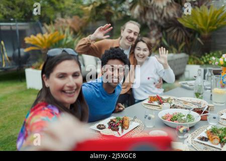 Happy couples taking selfie at patio lunch table Stock Photo