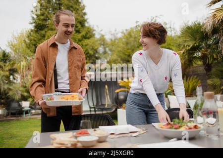 Young couple setting patio table for lunch Stock Photo