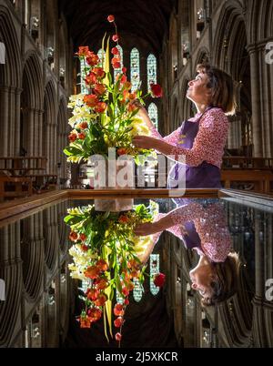 Caroline Baldwin puts the finishing touches to a floral display at Ripon Cathedral in North Yorkshire, that forms part of a celebration of the life and legacy of Ripon Cathedral's founding father, Wilfrid. Picture date: Tuesday April 26, 2022. Stock Photo