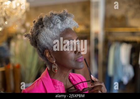 Thoughtful senior shop owner looking away Stock Photo