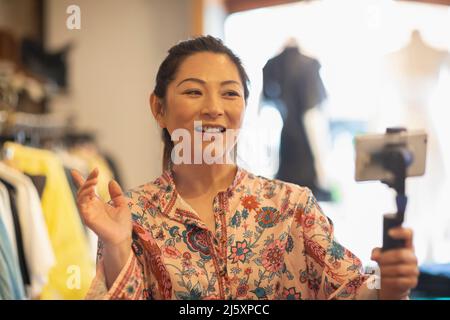 Female influencer vlogging in clothing boutique Stock Photo