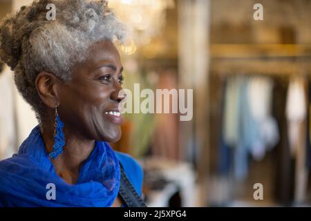 Portrait thoughtful senior female shop owner looking away Stock Photo