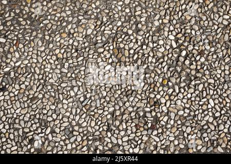 Full frame pebbles imbedded in concrete pavement background texture Stock Photo