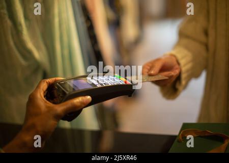 Close up customer with credit card paying at credit card reader Stock Photo