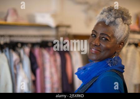 Portrait confident senior woman in clothing boutique Stock Photo