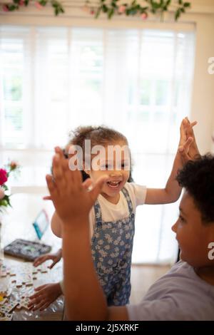 Happy brother and sister high fiving Stock Photo
