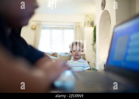 Girl watching brother using laptop Stock Photo