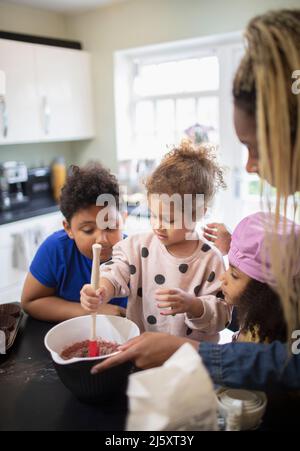 Mother and kids baking in kitchen Stock Photo