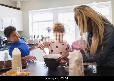 Mother and kids baking in kitchen Stock Photo