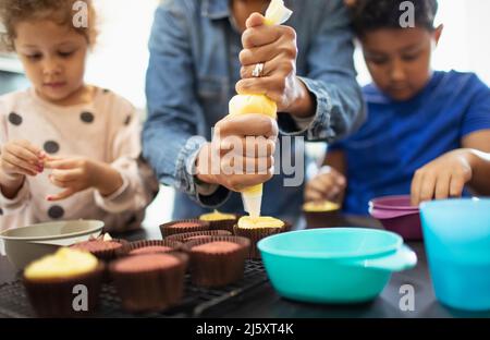 Mother and kids decorating cupcakes Stock Photo
