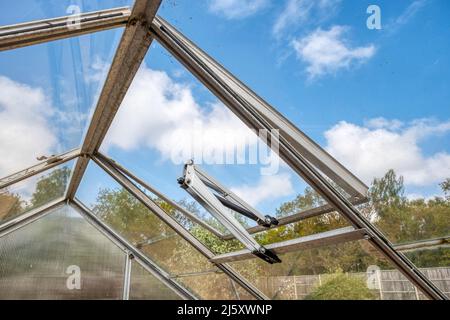 Heat-sensitive automatic window opener for ventialtion in a greenhouse. Stock Photo