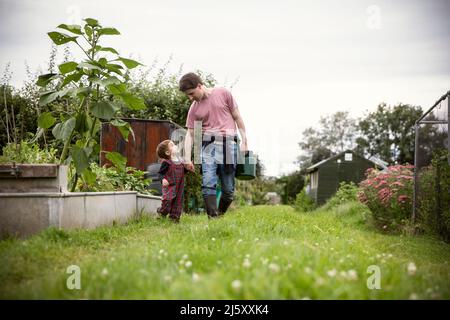 Father and toddler son walking in garden Stock Photo