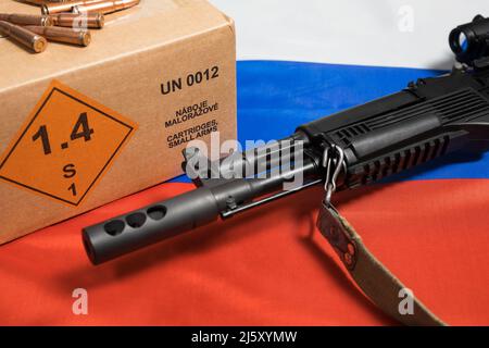 Closeup of a rifle on the Russian flag with a box of 7.62x39 rifle ammunition. Translation box: 'Cartridges, small arms.' Kalashnikov Izhmash Saiga MK Stock Photo