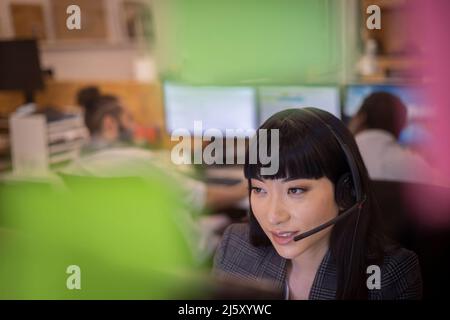 Businesswoman in headset working in office Stock Photo