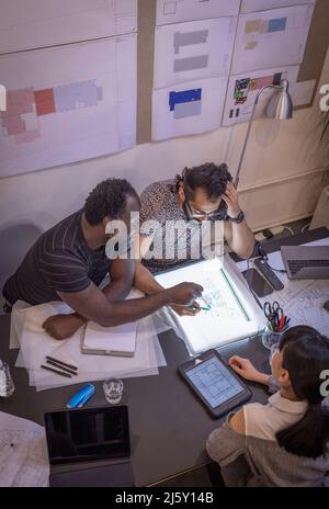 Architects discussing schematics in conference room meeting Stock Photo