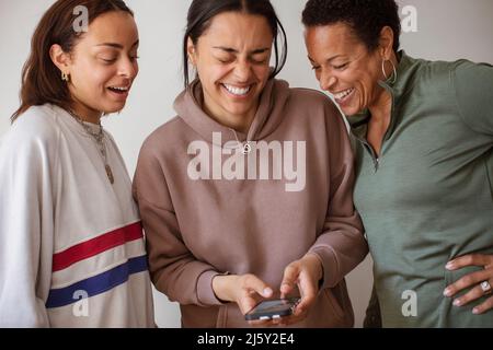 Happy mother and daughters using smart phone Stock Photo