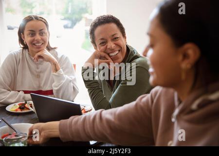 Happy mother and young adult daughters talking at home Stock Photo