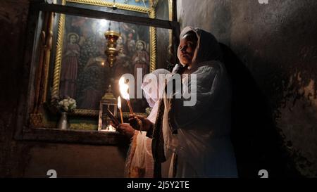 Ethiopian Orthodox Christians hold candles as they take part in the Holy Fire ceremony in Deir El-Sultan monastery adjacent to the Church of the Holy Sepulchre on April 23, 2022 in Jerusalem, Israel. Ethiopian Christians commemorate events around the crucifixion of Jesus Christ, leading up to his resurrection on Easter which in the Amharic language, is referred to as Fasika.