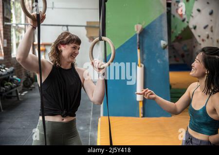Happy female rock climbers training at gymnastics rings Stock Photo