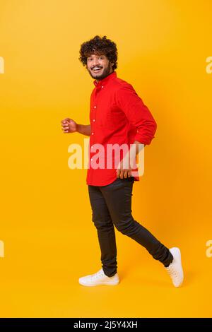 Merry indian male employee wearing smart casual shirt standing isolated on orange, studio shot of cheerful businessman. Success concept Stock Photo
