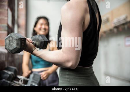 Close up woman working out with dumbbell in gym Stock Photo
