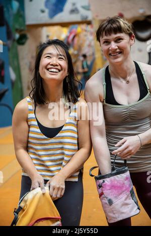 Happy female rock climber friends with chalk bags Stock Photo