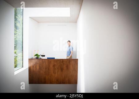 Portrait confident male engineer at desk with wind turbine models Stock Photo