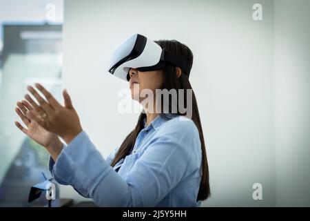 Woman gesturing, using VR headset Stock Photo