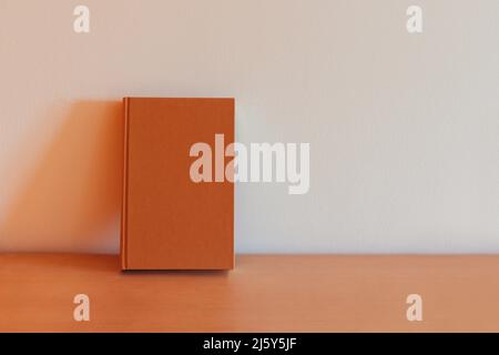 Brown hardcover book on a bookshelf isolated Stock Photo