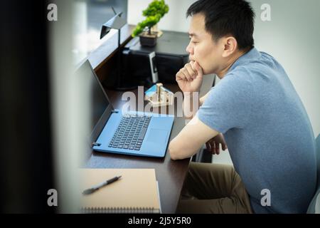 Thoughtful male engineer working at laptop in office Stock Photo