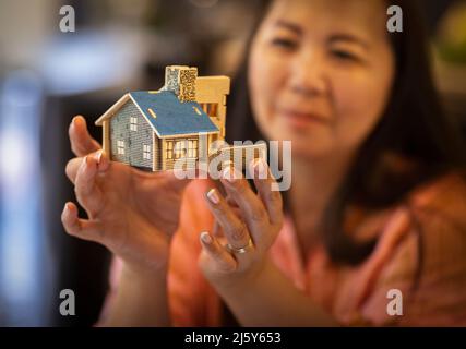 Close up female architect holding house model Stock Photo