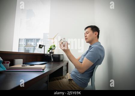 Male engineer looking at house model at office desk Stock Photo
