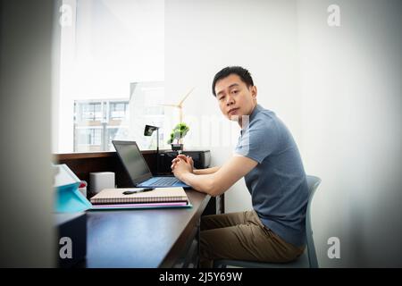 Portrait confident male engineer working at laptop in office Stock Photo