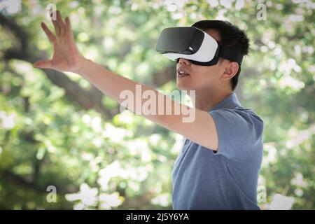 Man gesturing, using VR headset Stock Photo