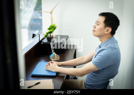 Happy male engineer sitting at desk in office Stock Photo