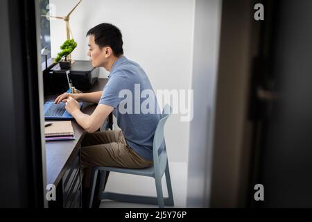 Male engineer working at laptop in office Stock Photo