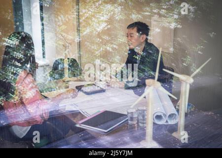 Engineers with wind turbine models meeting in office Stock Photo