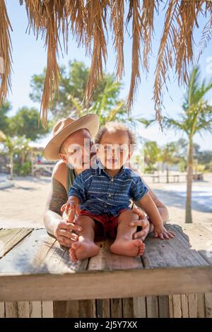 Portrait happy father and toddler son at beach hut Stock Photo