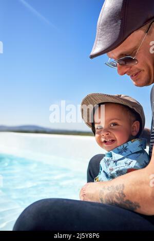 Portrait cute toddler boy with father on sunny beach Stock Photo