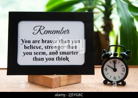 Motivational quote text on notepad - You are braver than you believe, stronger than you seem, and smarter than you think. Motivational concept Stock Photo