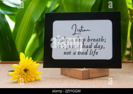 Motivational quote text on notepad - Take a deep breath, it's just a bad day, not a bad life. Stock Photo