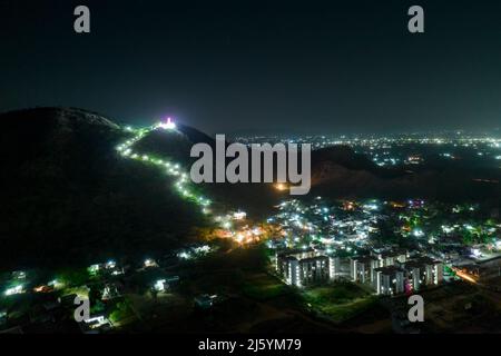 aerial night shot showing lights of city and leading up to temple on the top of hill in rajasthan jaipur showing the beauty of India Stock Photo