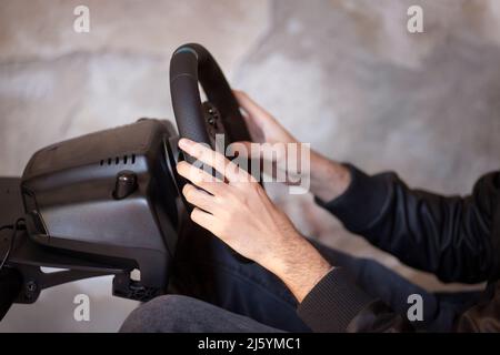 Hands of a Man on a Steering Wheel, While he Plays a Racing Game Stock Photo