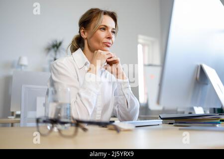 Female office worker looking at the computer screen Stock Photo