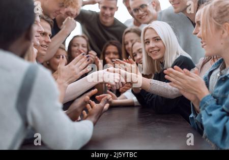 close up. handshake of young people to the applause of their friends. photo with copy space Stock Photo