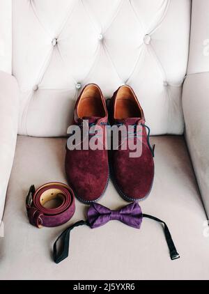 Burgundy suede shoes, belt and purple bow tie, fancy wedding, groom's accessories, male style and luxury fashion concept, close up, flat lay Stock Photo