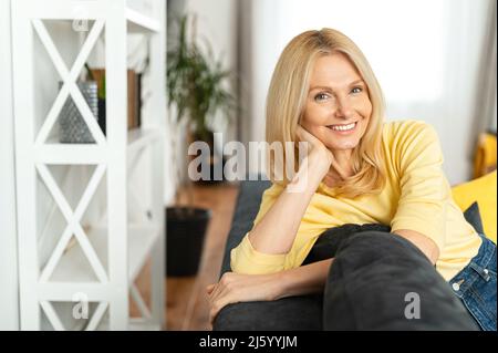 Headshot of smiling good-looking senior caucasian female looking at camera. Cheerful carefree woman resting at home, horizontal shot Stock Photo