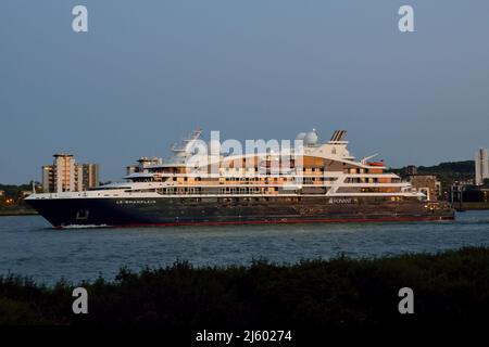 Ponant Cruises ship Le Champlain makes it's way down the river Thames at dusk after paying a port-call to London Stock Photo