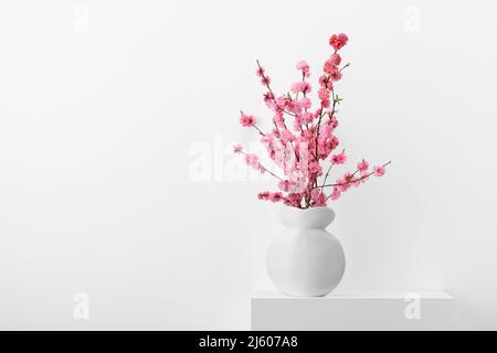 Flowering peach branches in a white vase Stock Photo
